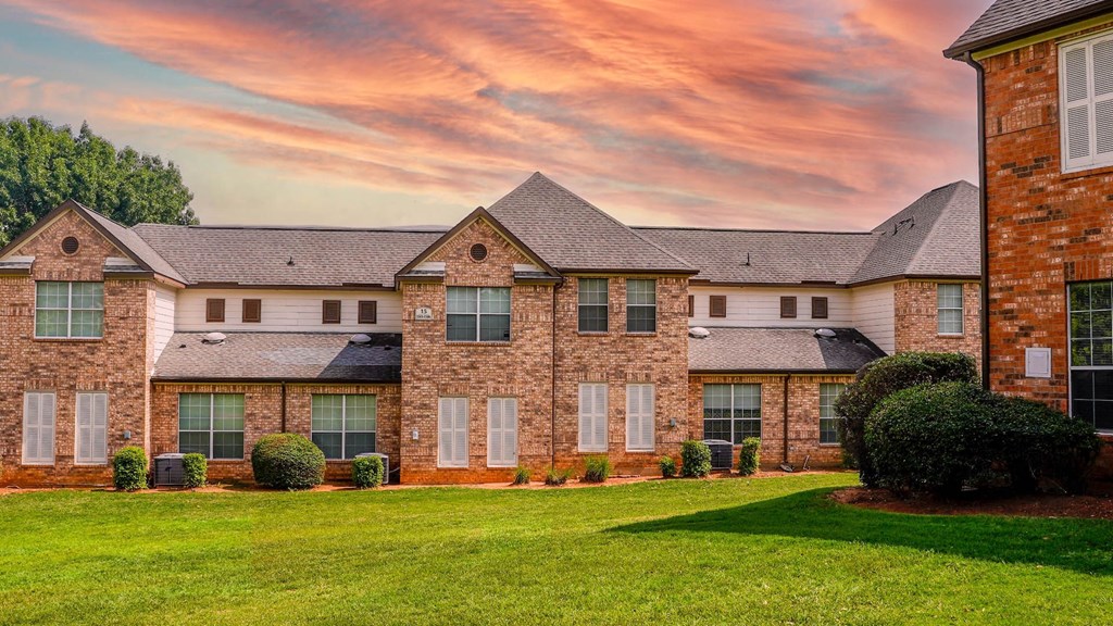 a large brick house with a lawn in front of it