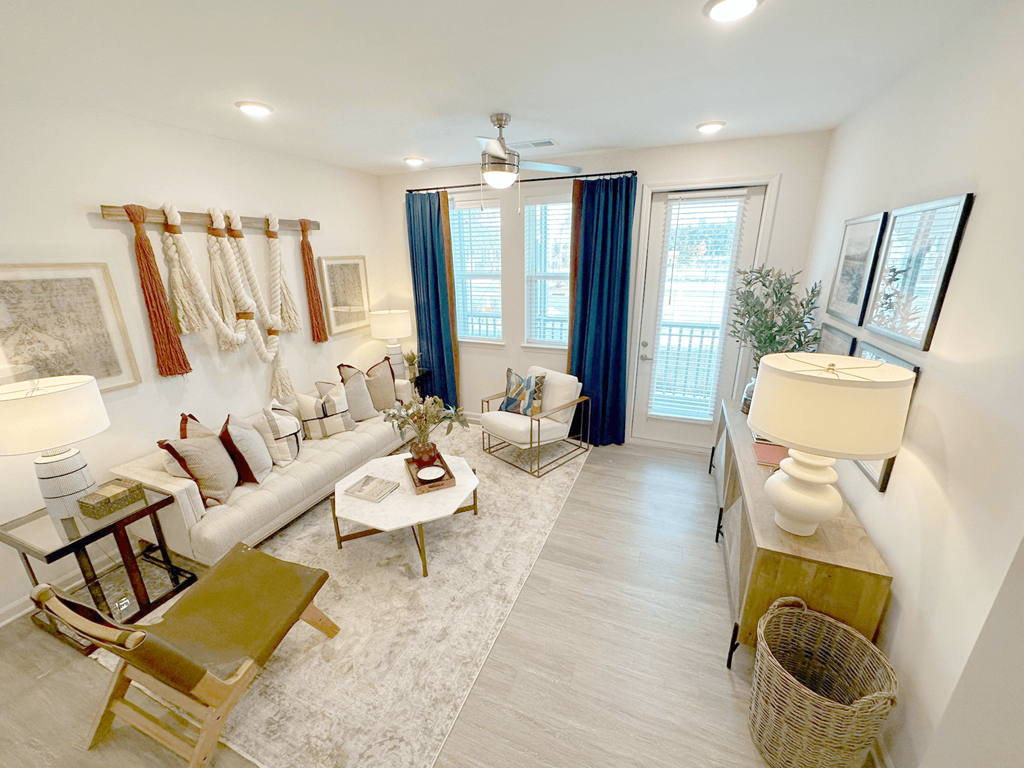A well-lit living room with a white sofa, a coffee table, and a rug.
