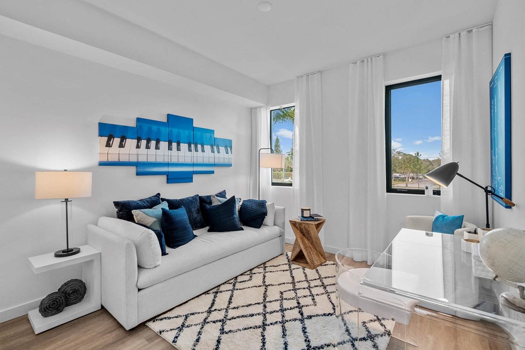 a living room with a white couch and a large window at Altis Blue Lake, Florida, 33467