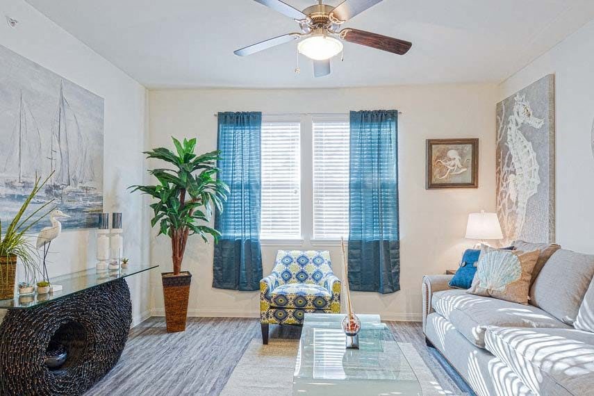 a living room with a couch and a ceiling fan