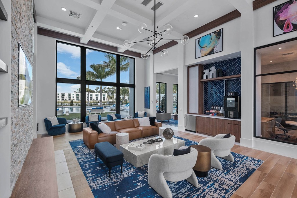 a living room with large windows and a couch and chairs at Altis Blue Lake, Lake Worth, FL, 33467