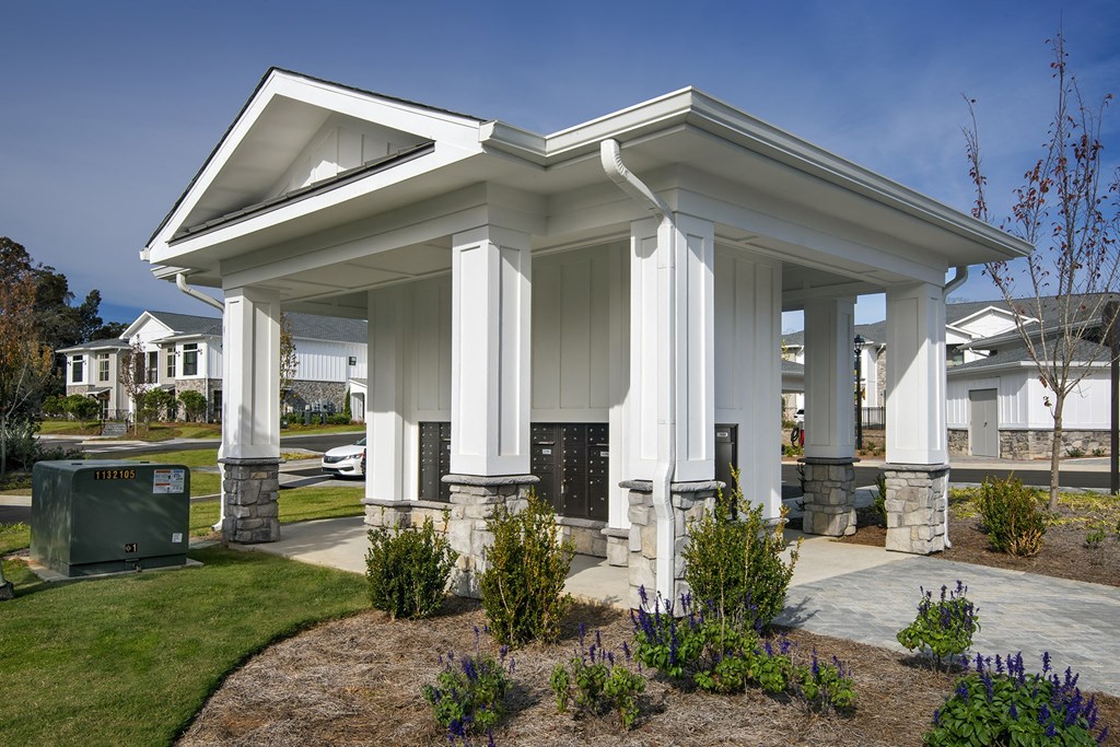 a covered porch with columns and a driveway