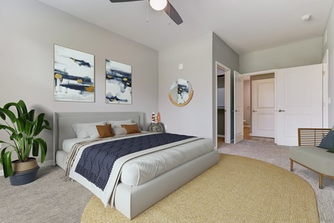 A bedroom with a large bed and a ceiling fan.