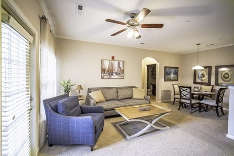 a living room with a couch and chair and a ceiling fan