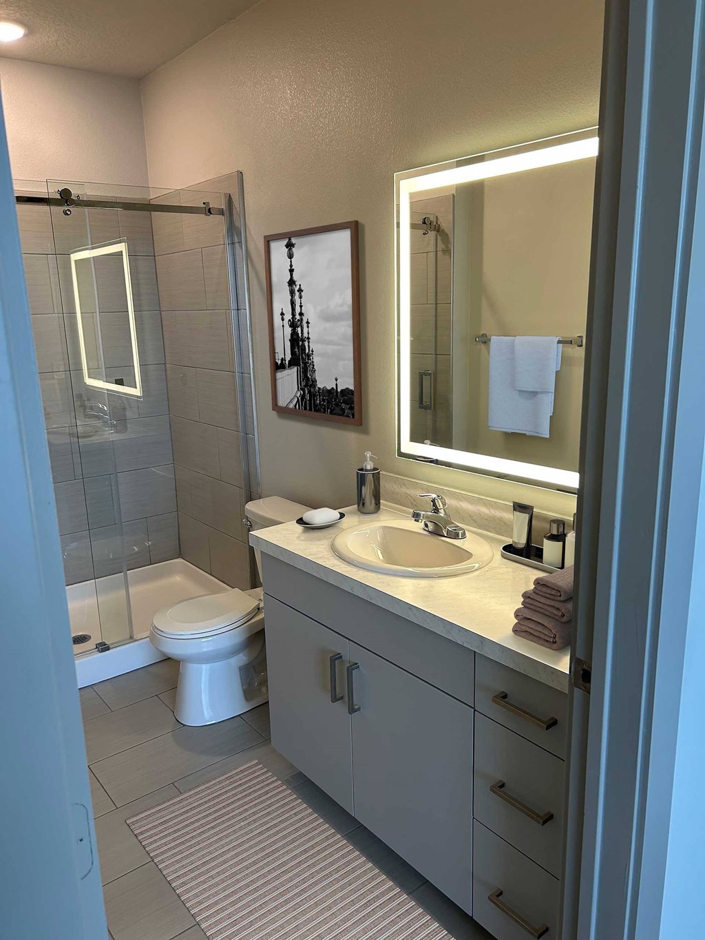 A bathroom with a toilet, sink, and mirror.
