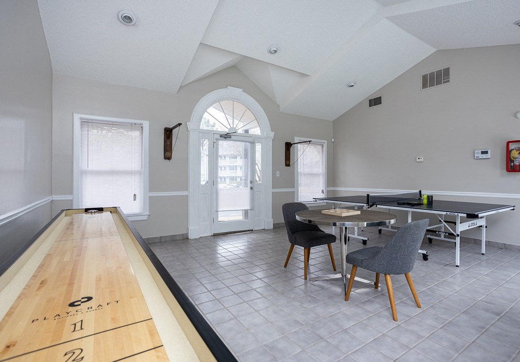 a dining area with a table and chairs and a ping pong table in a