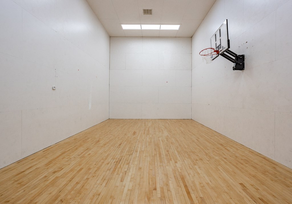 a large white room with a basketball hoop on the wall