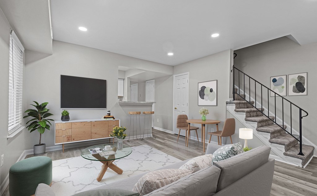 a living room with a couch and a table and a staircase