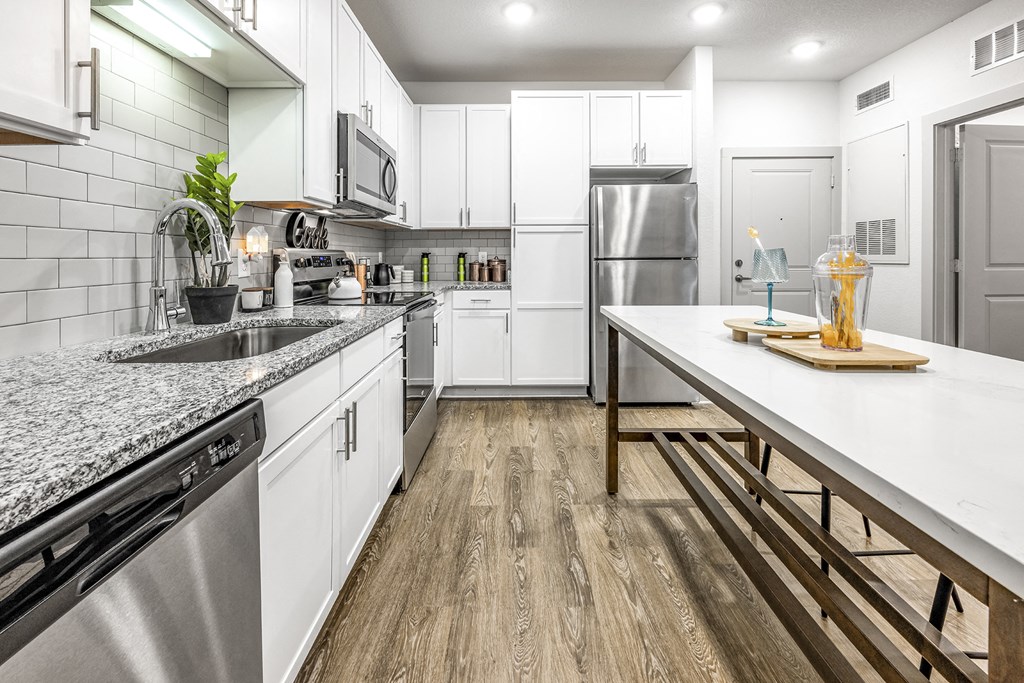 a kitchen with white cabinets and stainless steel appliances