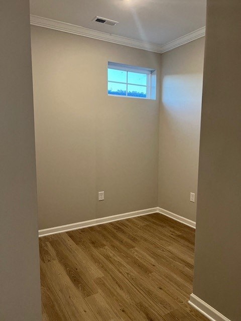 an empty room with a window and wooden floors