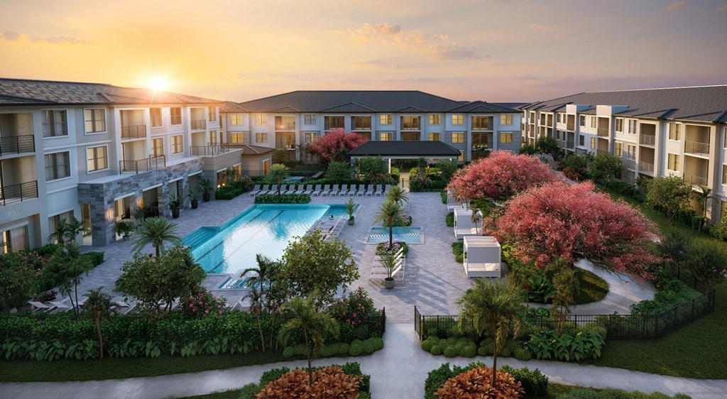 A beautiful sunset view of a resort with a pool and lush greenery.