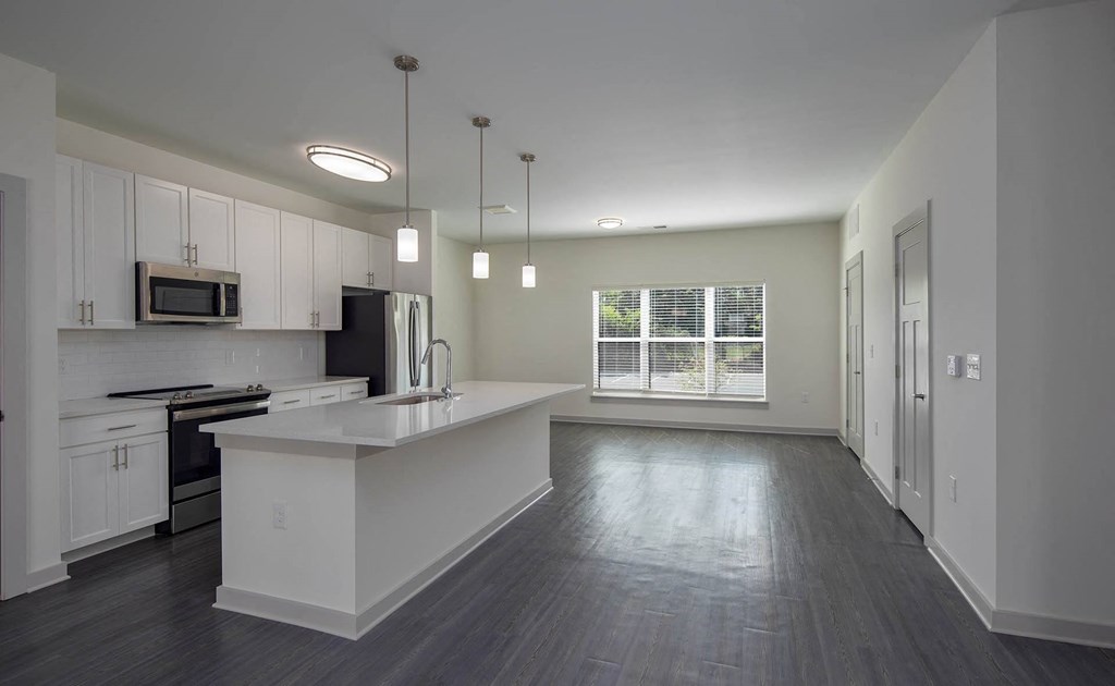 an empty kitchen with white cabinets and a white counter top