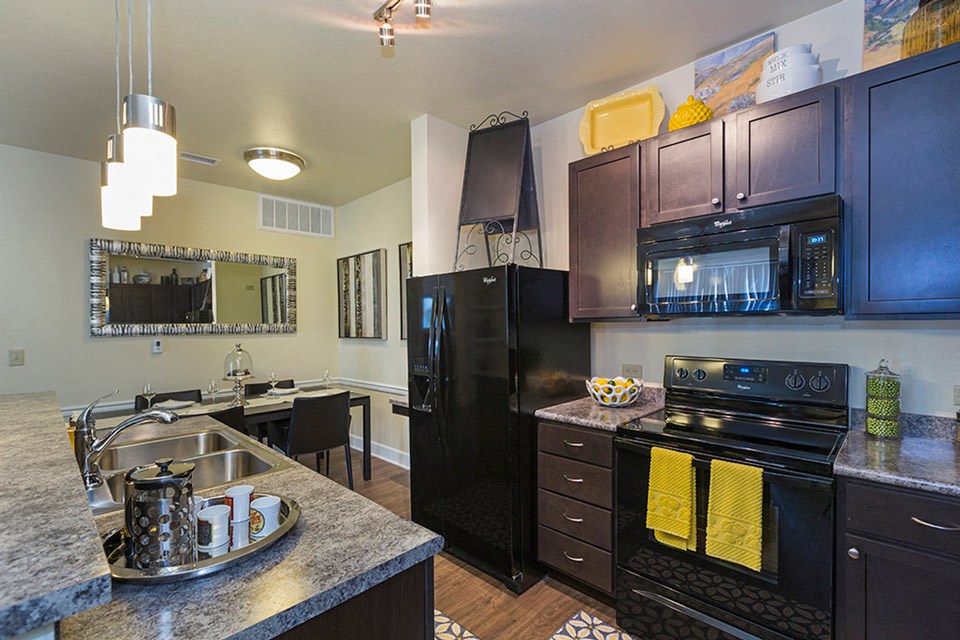 a kitchen with black appliances and granite counter tops