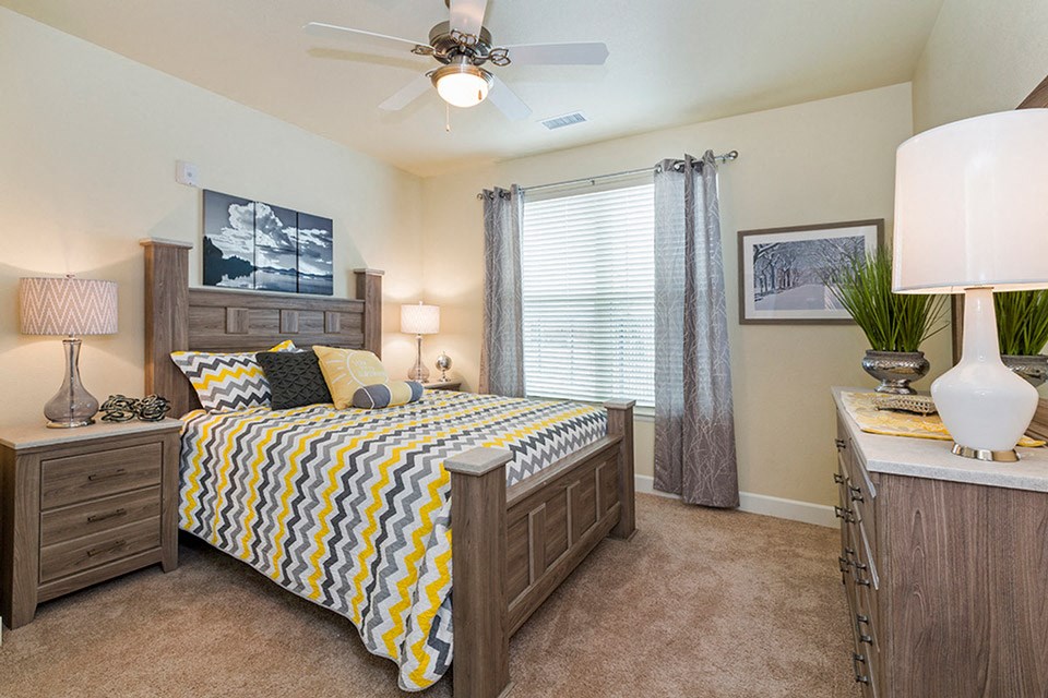 a bedroom with a bed and a ceiling fan