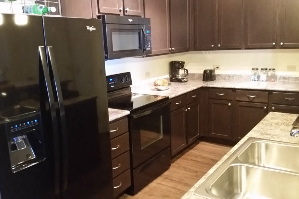 a kitchen with black appliances and wooden cabinets