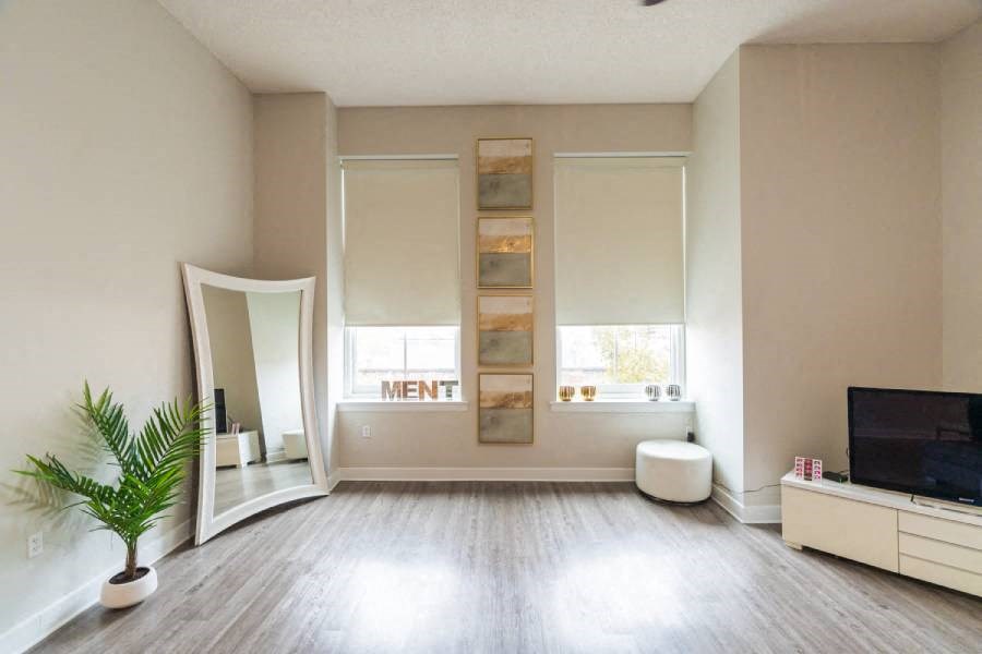 a white living room with a mirror and a tv