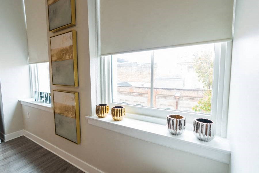 a window in a room with four cups on a window sill