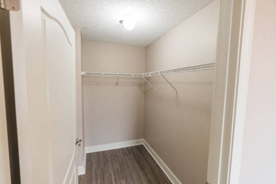 an empty bedroom with a white closet and a white door
