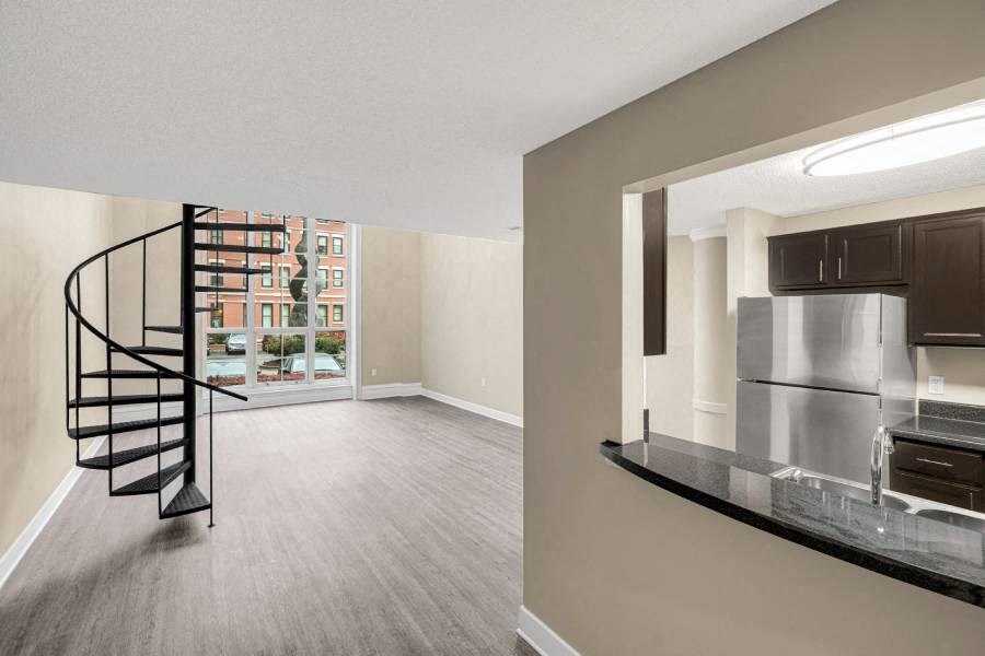 a living room with a spiral staircase and a kitchen