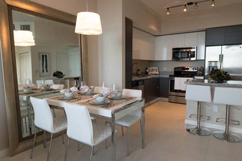 A modern kitchen with a dining table set for two.