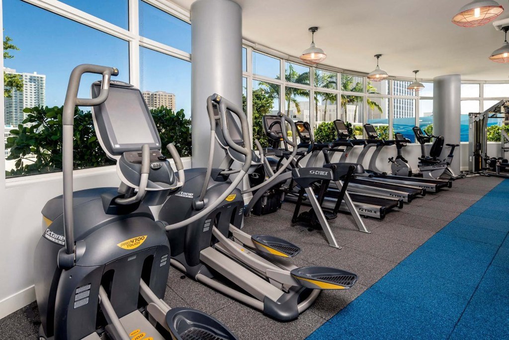 a gym with cardio equipment and a large window with a view of the ocean at Regatta at New River, Fort Lauderdale, FL