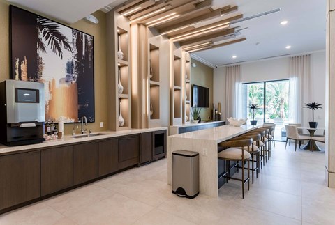 A modern kitchen with a long counter and a large painting on the wall.