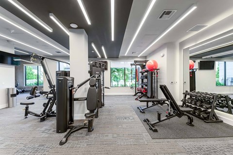 A gym with a variety of equipment including weights and machines.