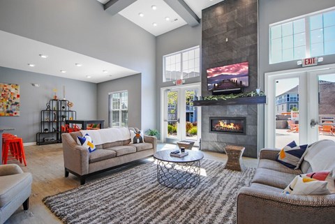 A living room with a fireplace and a television on the wall.