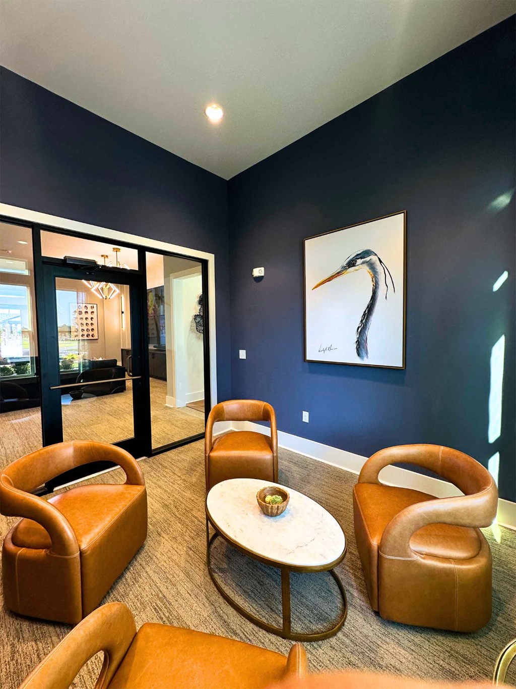 a living room with blue walls and leather chairs and a table