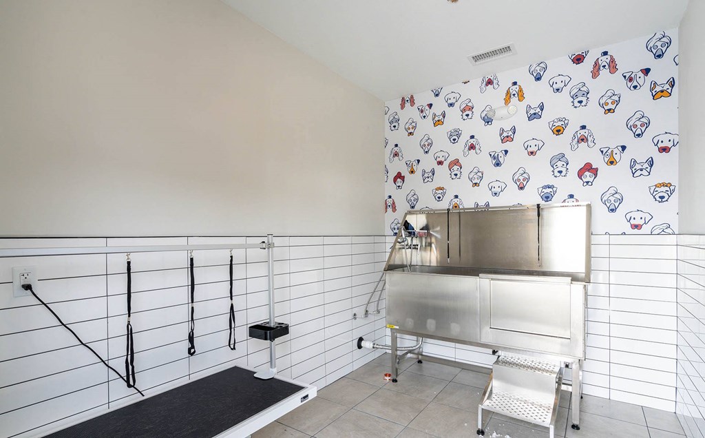 a kitchen with a stainless steel counter and a wall covered in tiles