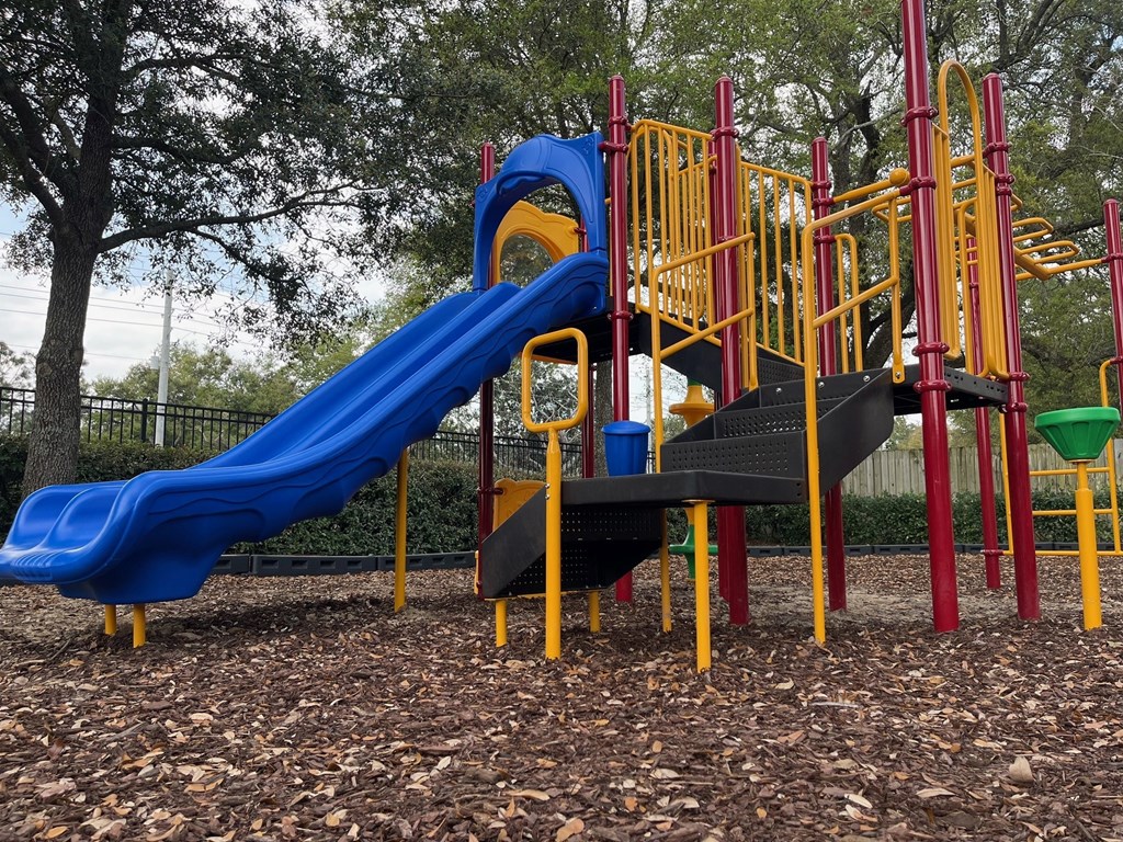 a playground with a blue slide and other playground equipment