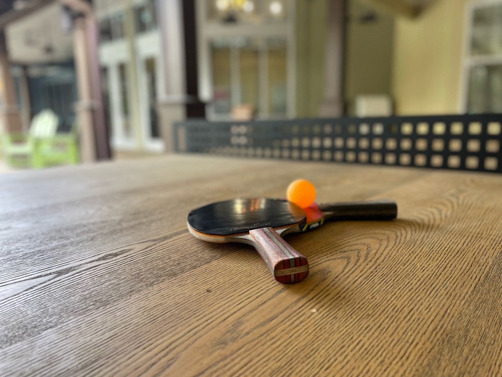 a spoon and a ball on a wooden table