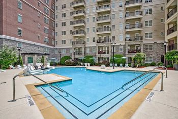A large swimming pool in front of apartment buildings.