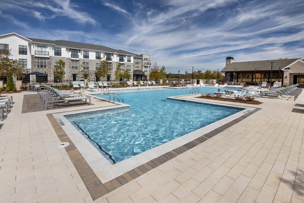 the resort style swimming pool is next to a building with a resort style pool