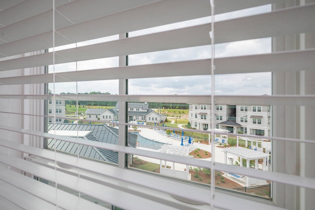 a view from a window of a building with white blinds