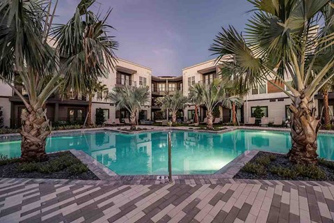 Apollo Beach, FL, Luxury Apartments With In-Unit Washer and Dryer - The Citizen at Waterset - Swimming Pool Surrounded By Palm Trees, Landscaped Decking, and Lounge Chairs.