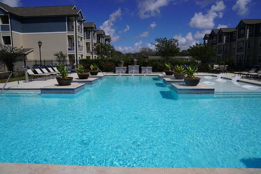a large swimming pool in front of an apartment building