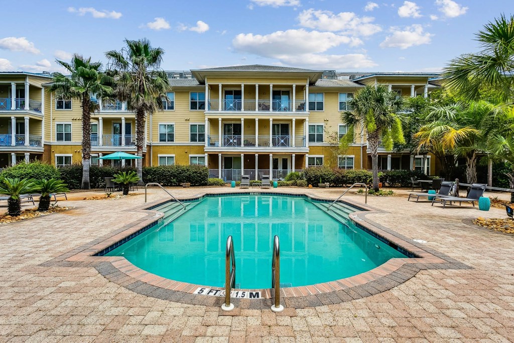 a large swimming pool in front of an apartment building