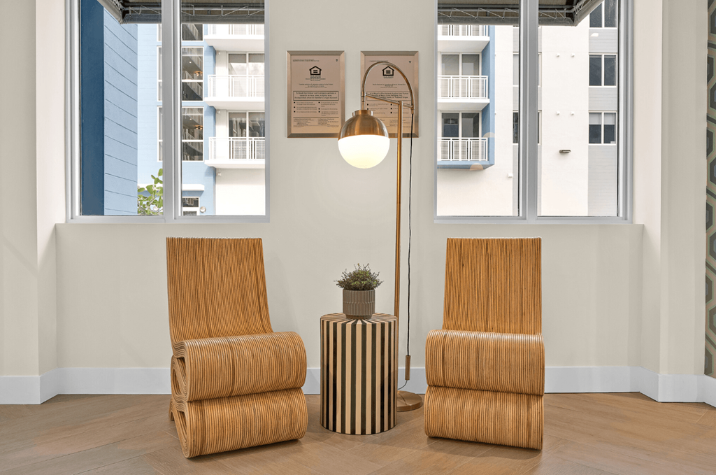 a living room with two chairs and a table and a lamp