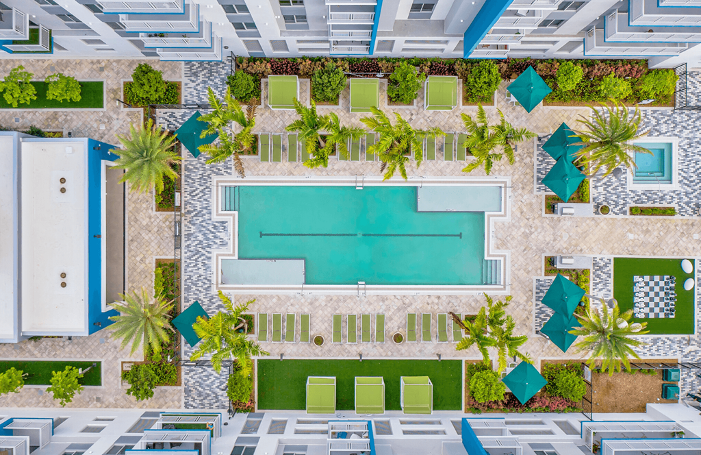 a pool area of a hotel with a swimming pool and palm trees