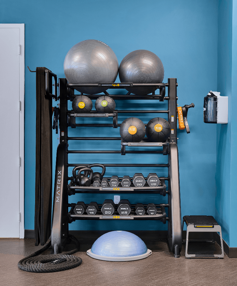 a shelf with spheres and helmets on it against a blue wall