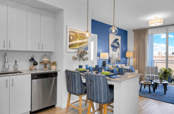 a kitchen and dining room with blue walls and a table with blue chairs