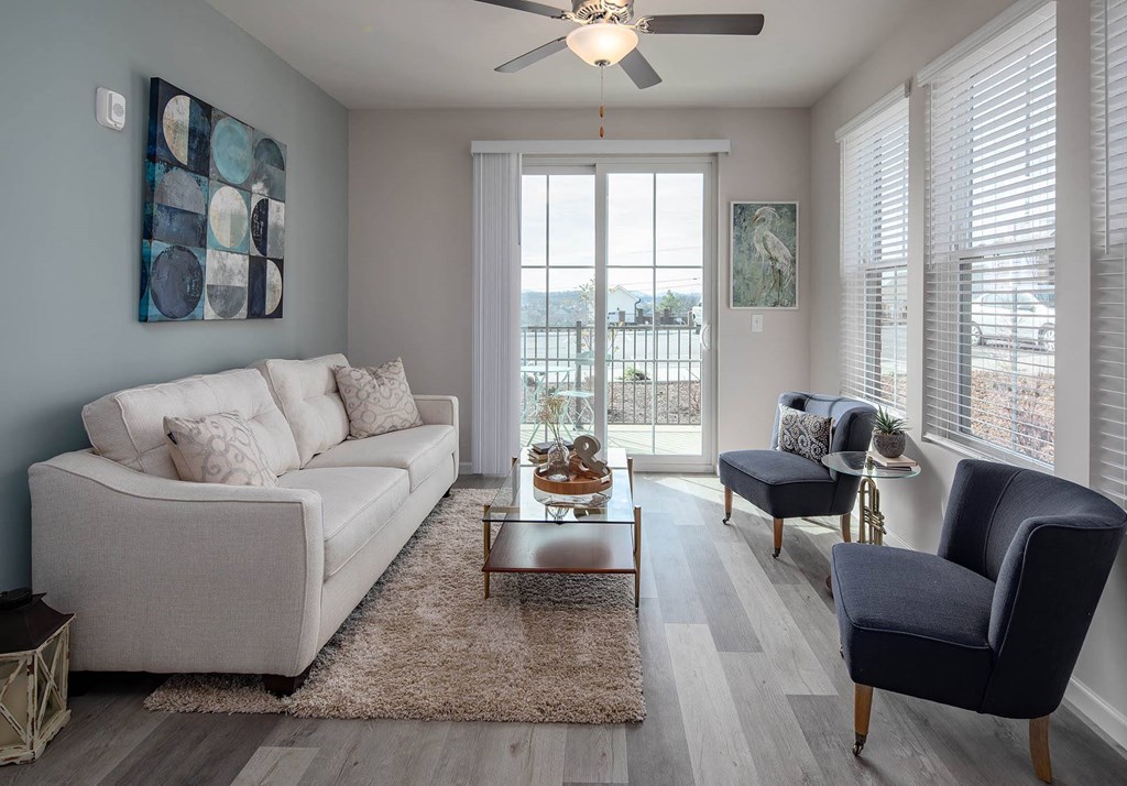 a living room with a ceiling fan and a sliding glass door