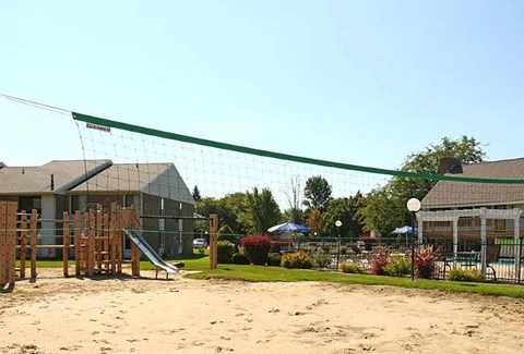 A volleyball net is set up in a sandy area.