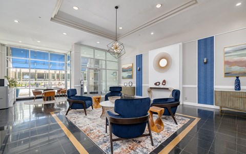 A living room with blue chairs and a chandelier.