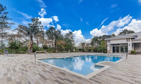 A swimming pool surrounded by a wooden deck and trees.