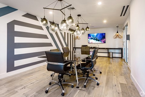 A conference room with a striped wall and a television mounted on the wall.