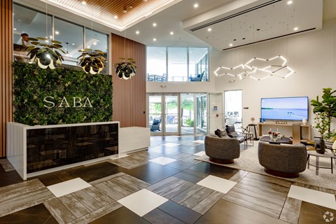 A modern lobby with a green wall and a reception desk at Saba Pompano Beach, Pompano Beach, 33062