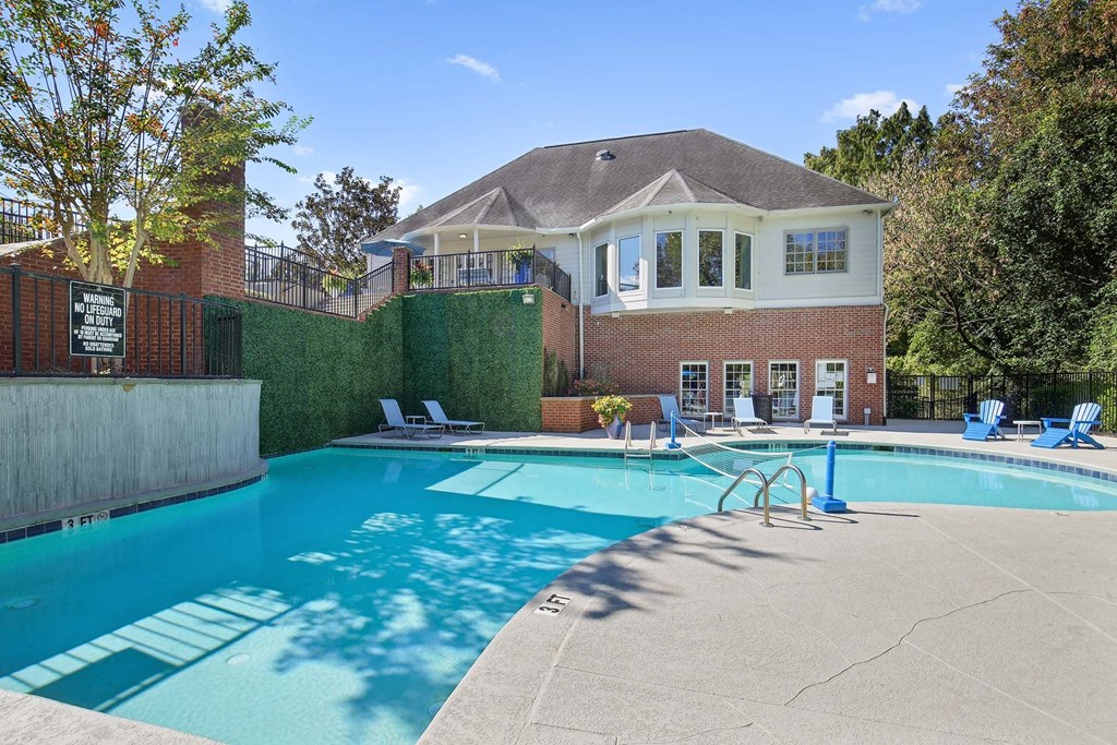 a swimming pool with a house in the background