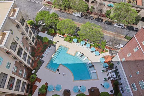 An aerial view of a pool surrounded by buildings.